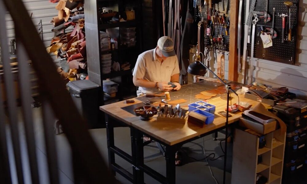 yampa valley bank video thumbnail, man wearing baseball cap working in a leather shop